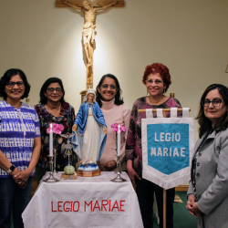 members of the legion of mary standing beside an altar